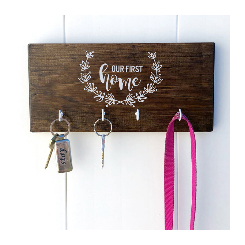 Our First Home key holder for wall, wooden key rack with 4 hooks, our first home with magnolia wreath, key holder for families - Bloom And Anchor